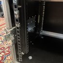 Interiér černého transportního kufru s hliníkovými hranami. Uvnitř jsou instalovány dvě vertikální montážní lišty pro rackové zařízení. Povrch vnitřk…