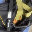 Černý kovový stojan s bílým nápisem RockStand®. Na stojanu je viditelná bílá štítková nálepka s technickými údaji a certifikacím GS. Vedle stojanu le…