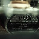 Detailní pohled na zadní část reproduktoru s černým štítkem. Na štítku je bílý nápis VOX AMPLIFICATION Ltd, CUSTOM LOUDSPEAKER SERIES a MODEL GSH-123…