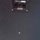 Detail zadní strany černého kytarového reproduktorového boxu s texturovaným povrchem. V horní části je umístěn ovládací panel s nápisem 1960AV 4x12 a…