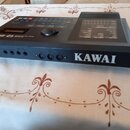 Černý elektronický modul značky KAWAI. Na horní části je displej, ovládací tlačítka a nápis Q-80. Přední panel obsahuje několik vstupů a výstupů, vče…