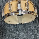 Světle hnědý dřevěný malý buben s chromovaným obručováním a mechanismem. Na chromované části je viditelné logo "Gretsch". Povrch dřeva vykazuje mírné…