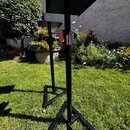 Dvě černé notovéstavy z kovového materiálu s trojúhelníkovým základnami. Mají jednoduchý hranatý tvar s nastavitelnou výškou a sklopnou deskou. Na ná…