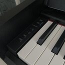 Detailní pohled na ovládací panel a klávesy digitálního pianina v černé barvě. Na panelu jsou viditelné nápisy DEMO SONG, PIANO/VOICE a METRONOME s d…