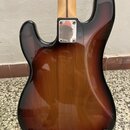 Zadní strana elektrické kytary s lakovaným povrchem v hnědém sunburst provedení. V horní části je vidět kovový kryt elektroniky připevněný čtyřmi šro…