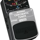 Černý chromatický tuner s kovovým stříbrným šasi a gumovou stupňovací pedagogy. Na horním panelu je digitální displej s nápisem PITCH a LED indikátor…