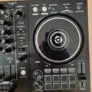 Detailní pohled na pravou část DJ kontroleru černé barvy. V horní části jsou tlačítka s nápisy IN/4BEAT, OUT, RELOOP/EXIT, CUE/LOOP a MASTER. Uprostř…