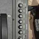 Detail ovládacího panelu kytarového komba v černé barvě. Na horní části je nápis KATANA 50 a logo značky Boss. Panel obsahuje vstup INPUT a řadu otoč…