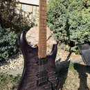 Elektrická kytara s tmavě fialovým průsvitným lakem a viditnou strukturou dřeva. Nástroj má dva humbuckery, jeden ovládací knoflík hlasitosti a jeden…