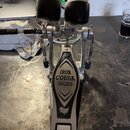 Kovový basový pedál s černými beatery. Na šlapce je nápis IRON COBRA 200 a ve spodní části logo TAMA. Povrch pedálu vykazuje známky používání a lehké…