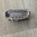 Fotografie znázorňuje elektrický snímač typu humbucker v kovovém šasi. Snímač má stříbrnou barvu a je obalen v pleteném stínění. Na povrchu nejsou vi…