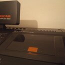 Černý víko s nápisem TASCAM MIDISTUDIO 688 v oranžové a bílé barvě. Pod ním je část černého zařízení s nápisem dbx NOISE REDUCTION SYSTEM a ovládacím…