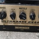 Zlatý basový zesilovač s černými ovládacími knoflíky a analogovým VU metrem vlevo. Na předním panelu jsou nápisy ULTRABASS BX4410, 450-WATT BASS AMPL…