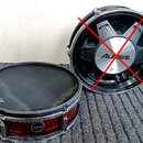 Na fotografii jsou dva elektronické bubny značky Alesis. Levý buben má červený trup, černou membránu s nápisem Alesis a chromované obruče. Pravý bube…