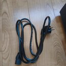 Černý napájecí kabel s evropskou síťovou vidlicí a konektorem typu C13. Na izolaci kabelu je bílý nečitelný nápis. Povrch kabelu a konektorů je v dob…