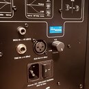 Zadní panel černého studiového monitoru s různými konektory a ovládacími prvky. Jsou zde vstupy s nápisy RCA IN (-10 dBV), TRS IN (+4 dBu) a XLR IN (…