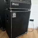 Černý basový kombozesilovač složený z hlavního zesilovače a reproduktorové skříně. Na horním modulu je nápis SVT-450 a logo Ampeg, na spodní skříně j…