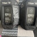 Dvě černé aktivní reproduktory v černých transportních obalech. Na obalech je bílý nápis Titan™ 12 a logo Wharfedale Pro. Na zadním panelu reprodukto…