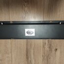 Černý obdélníkový předzesilovač nebo efektový pedál v kovovém provedení. Na horní straně je bílá čtvercová nálepka s logem MOD a nápisem Model: E-MOD…