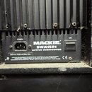 Detail zadní strany černého aktivního subwooferu. Na přístrojovém panelu je nápis MACKIE SWA1501 ACTIVE SUBWOOFER, napájecí konektor označený jako PO…