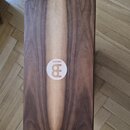 Dřevěný cajon s hnědým povrchem a světlým pruhem uprostřed. Uprostřed je bílý kulatý štítek s logem a nápisem MEINL. Povrch nástroje vypadá hladce a…