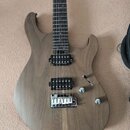 Elektrická kytara s hnědým dřevěným povrchem těla a hmatníkem. Nástroj má dva humbuckery s nápisem Seymour Duncan, jeden ovládací knoflík a přepínač.…
