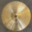 Zlatý kovový činel typu splash s koncentrickým žebrováním povrchu. V horní části je nápis "Paiste" a v dolní části označení "Splash 10"". Povrch vyka…