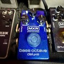 Modrý efekt pedál s kovovým povrchem a třemi ovládacími knoflíky. Na přední straně je bílé logo MXR a nápis BASSINNOVATIONS, dále popisky MID+, GROWL…