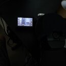 Fotografie zachycuje černý digitální záznamový zařízení s displejem, na kterém je vidět běžící zvuková vlna a časovač 00:56. Vedle zařízení je umístě…