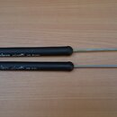 Dvě čebalové lišty s černými gumovými rukojetmi a kovovými hroty zakončenými kroužkem. Na horní liště je bílý nápis vic Firth Rhythmic HD Sweep a na…