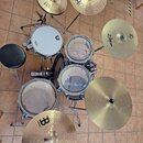 Celá bicí souprava s činely a černým sedákem. Na bílém tom je logo Pearl, na ostatních bubnech jsou čela značky Evans. Činely mají nápisy MEINL HCS a…
