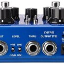 Modrý kytarový pedál s černými oválnými knoflíky a kovovými přepínači. Na zadní straně jsou čtyři konektory s popisky INPUT, LEVEL (+4dB LINE / -10dB…