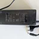 Černý síťový adaptér s napojovacími kabely. Na štítku je uveden text AC/DC ADAPTER, MODEL: ZS120A-3405000, INPUT: 100-240V ~ 2.0A Max., 50/60Hz, OUTP…