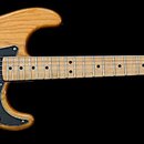 Elektrická kytara s přírodním dřevěným povrchem těla a hmatníkem. Na hlavě je vidět nápis Fender STRATOCASTER a pod ním menší nečitelný text. Černý p…