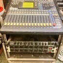 Digitální mixážní pult značky YAMAHA, model OXY 5, umístěný v transportním case. Zařízení má šedé tělo s modrými prvky, LCD displej a řadu posuvníků.…