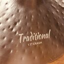 Detailní záběr na kovový činel s kovaným povrchem (hammered). Na povrchu je bílý nápis „Traditional“ a pod ním text „17" CRASH“. Povrch vykazuje drob…