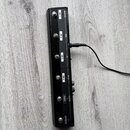 Černý obdélníkový pedál s řadou šesti stoupacích spínačů. Na pravé straně jsou bílé nápisy: BOOSTER, CH 1, MOD, CH 2, FX, CH 3, DELAY, CH 4, REVERB,…