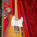 Elektrická kytara typu Telecaster s javorovým hnedým hmatníkem a tělem v přechodovém žlutě-hnědém odstínu (sunburst) s viditnou strukturou dřeva. Nás…