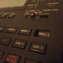 Detailní pohled na ovládací panel černého elektronického zařízení. Jsou vidět tlačítka s bílými nápisy RESET, CHECK, MEMO 1, MEMO 2, TRT, RTZ, LOC 1…