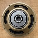 Fotografie znázorňuje reproduktor s kovovým rámem v zlatavé barvě. Na středovém magnetu je bílý nápis CUSTOM DESIGN a FOR BLACKSTAR AMPLIFICATION, po…