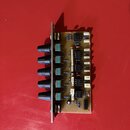 Elektronický modul na hnědé desce plošných spojů s pěti černými oválnými knoflíky. Na desce jsou připájené integrované obvody, kondenzátory a rezisto…