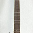 Červená elektrická kytara s tmavým hmatníkem a bílými tečkovanými značkami poloh. Na hlavě je viditelné logo „Gibson“. Na těle je nalepený bílý štíte…