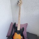 Elektrická basová kytara s korpusem v přechodovém žluto-černém odstínu (sunburst) a černým pickguardem. Na hlavě hmatníku je viditelné logo "Hofner".…