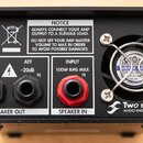 Zadní strana černého elektronického zařízení s kovovým šasi. Na levé straně jsou dva výstupy označené nápisy THRU a ATT -20dB, pod nimi je společný š…