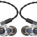 Dvě šupínkované in-ear sluchátka s průhledným plastovým tělem a černým opleteným kabelem. Na vnitřním centerXu obou sluchátek je viditelné logo znázo…