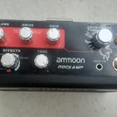 Černý kompaktní kytarový zesilovač s červeným ovládacím panelem. Na přístroji jsou nápisy VOLUME, DRIVE, GAIN, EFFECTS, TONE a značka ammoon POCKAMP.…