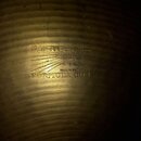 Detailní záběr na povrch mosazného činele s vyraženými nápisy. Je zde vidět logo PAISTE, nápis MADE IN SWITZERLAND a označení FORMULA 602. Mezi nimi…