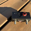 Černý kompaktní efekt pedál s texturovaným povrchem. Na přední straně je nápis DMC.micro PRO a logo Disaster Area Music Technologies. V horní části j…