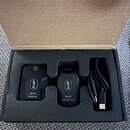 V kartonové krabici s pěnovým vložkem jsou dvě černé bezdrátové jednotky a černý USB kabel. Na levé jednotce je nápis JOYO, JW-07 RECEIVER a na pravé…