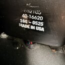 Detailní záběr na černý povrch s bílými nápisy. Jsou zde čitelné řady textu: 40-16620, 166-0525 a MADE IN USA. Nad nimi je viditelný nečitelně smazan…